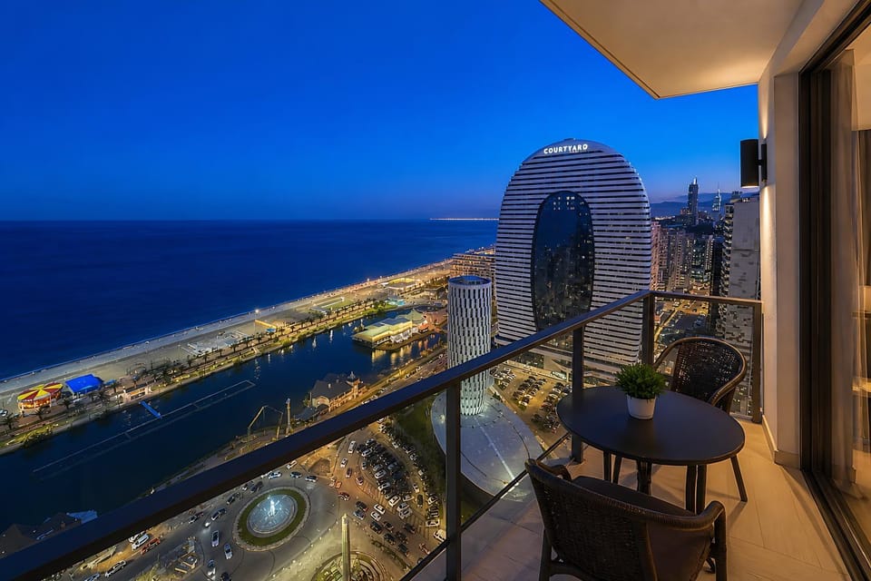 Property building, Night, Natural landscape, View (from property/room), Balcony/Terrace, Living room, Seating area, City view, Sea view