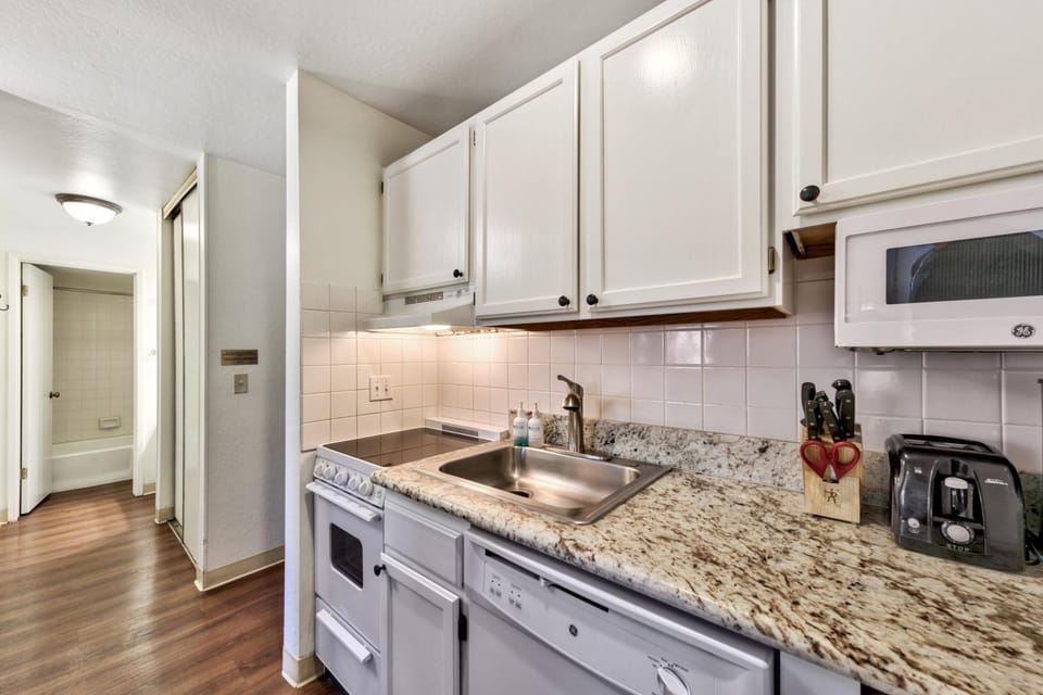 Kitchen or kitchenette, dishwasher, furniture, microwave, stove, toaster