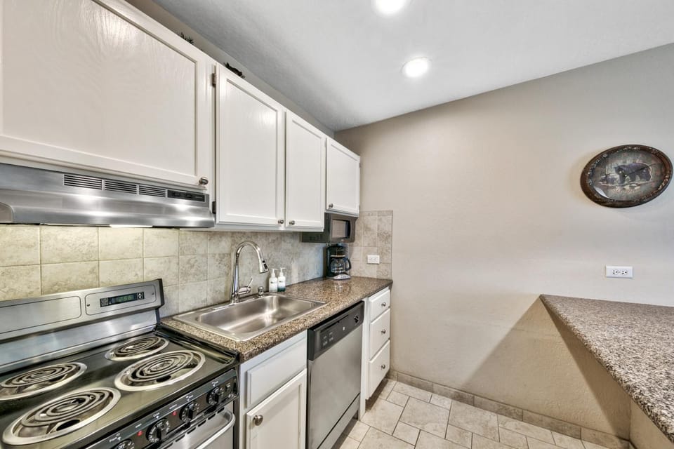 Kitchen or kitchenette, dishwasher, furniture, microwave, oven, stove