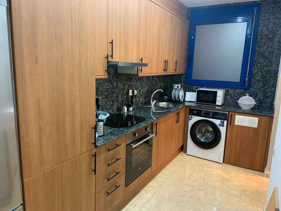 Kitchen or kitchenette, microwave, oven, stove, toaster, washing machine