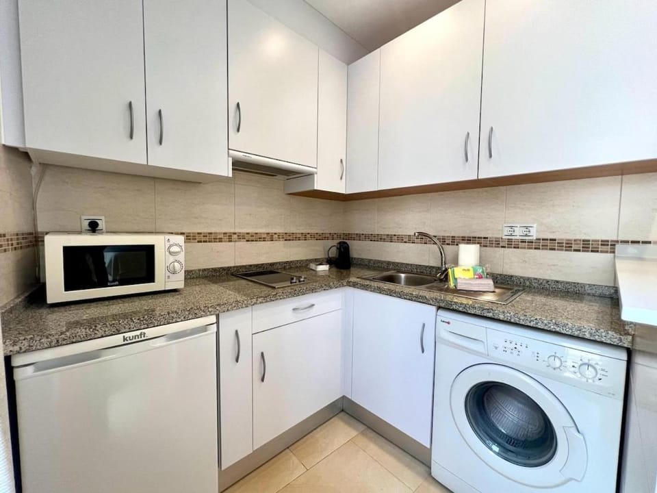 Kitchen or kitchenette, dishwasher, microwave, stove, toaster, washing machine