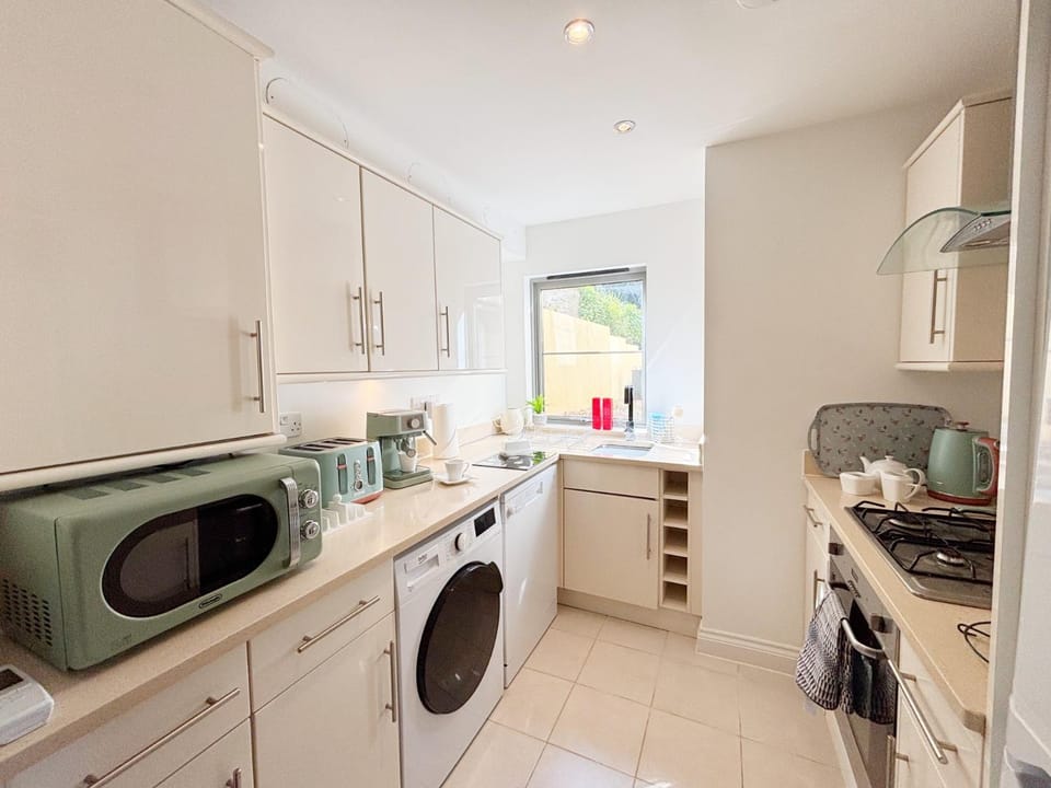 Kitchen or kitchenette, dishwasher, microwave, stove, toaster, washing machine