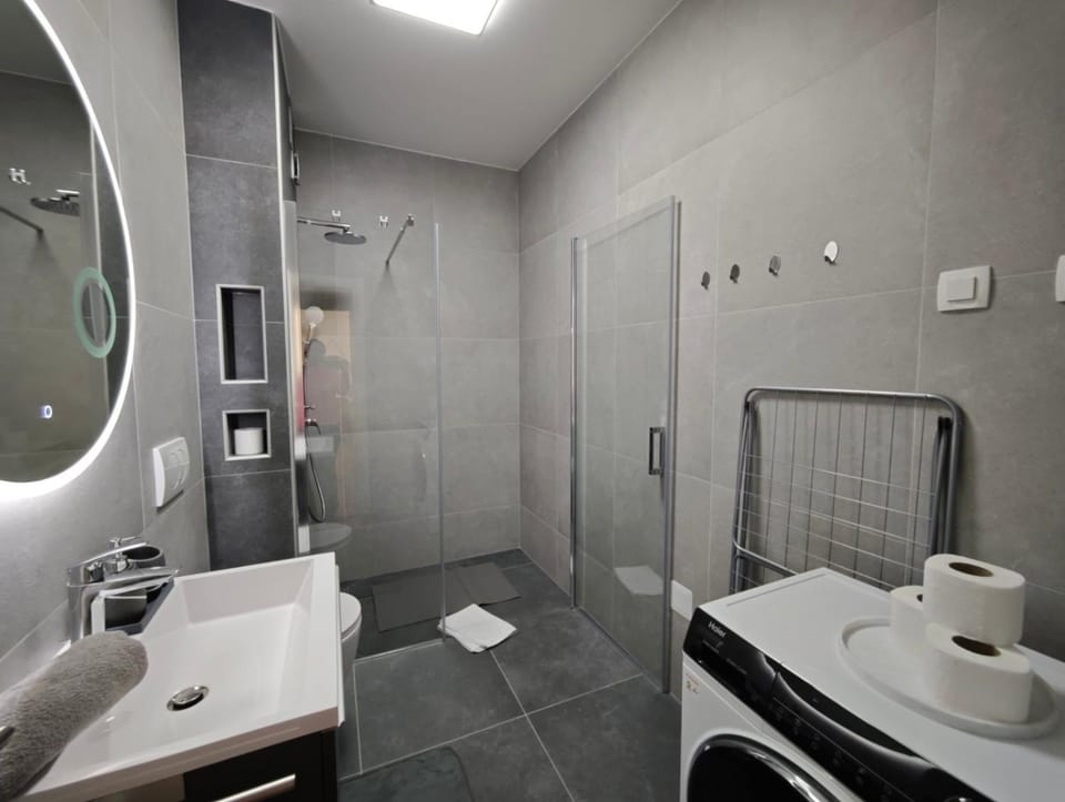 Shower, Toilet, Bathroom, hair dryier, towels, washing machine
