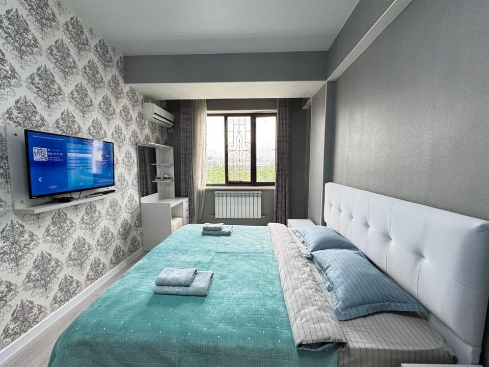 One bedroom and a guest room in residential building Panfilov Apartment in Almaty Region, Kazakhstan