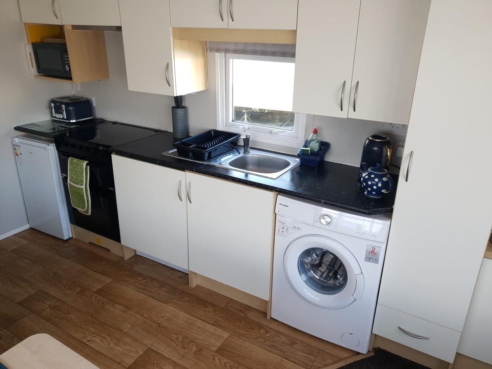 Kitchen or kitchenette, furniture, minibar, stove, towels, washing machine
