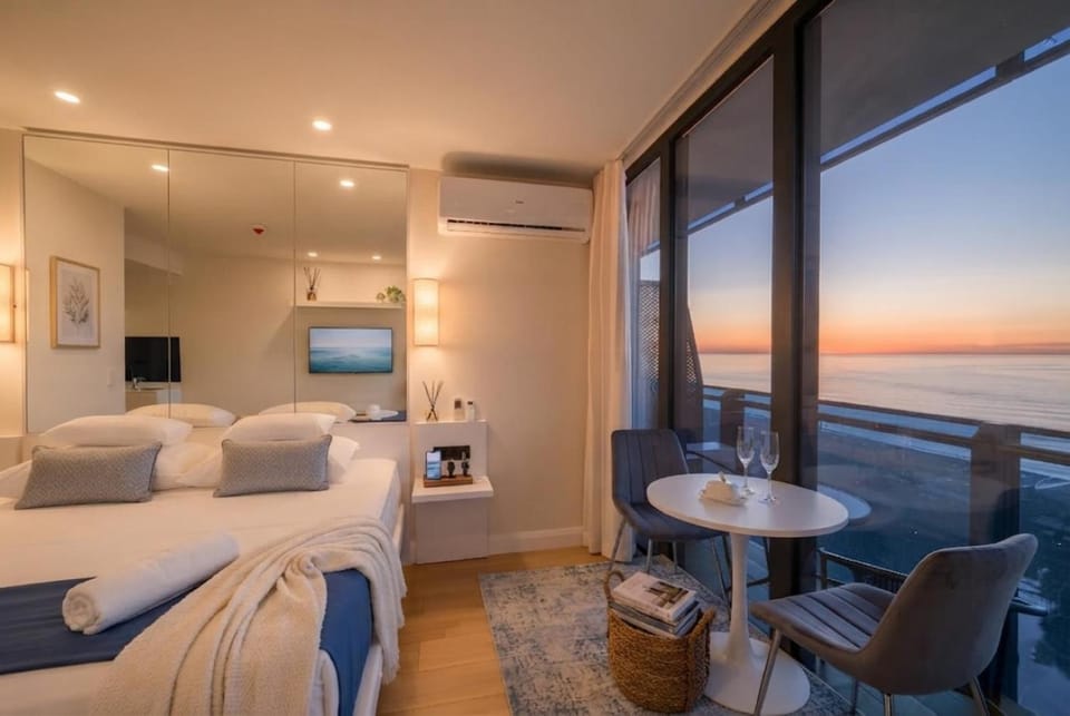 Communal lounge/ TV room, Bed, Natural landscape, TV and multimedia, View (from property/room), Balcony/Terrace, Living room, Photo of the whole room, Seating area, Evening entertainment, Bedroom, Sea view, Sunrise, Sunset, air conditioner
