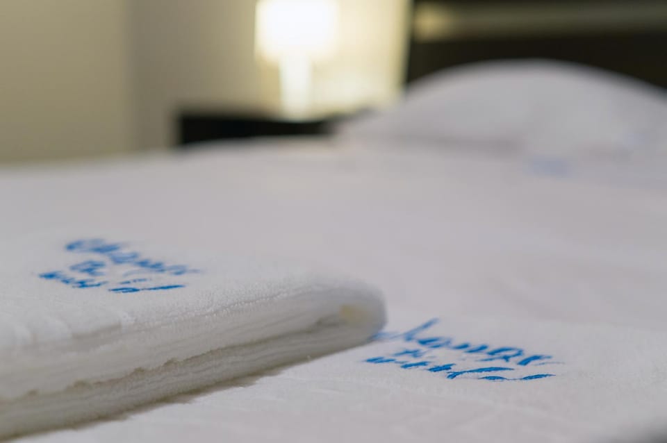 Bed, Photo of the whole room, Bedroom, Text overlay, towels