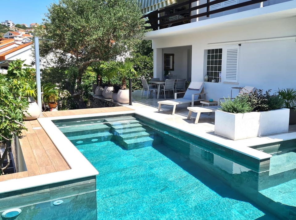 Property building, View (from property/room), Balcony/Terrace, Text overlay, Swimming pool