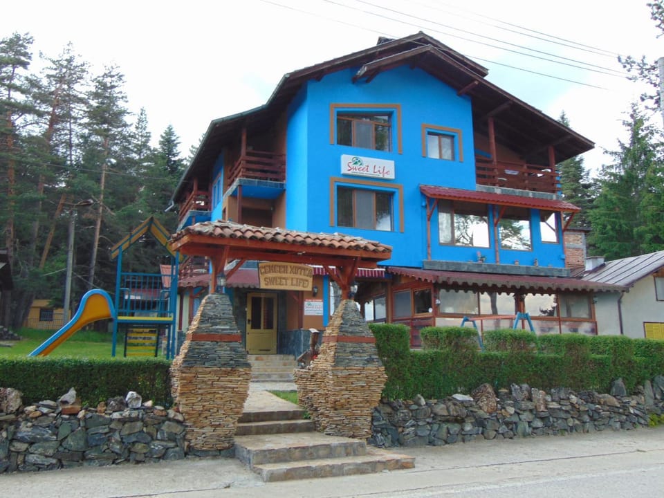 Communal lounge/ TV room, Facade/entrance, Property logo or sign, Children play ground, Garden, Balcony/Terrace, Decorative detail, Floor plan, Communal kitchen, Text overlay, Garden view, Lake view, Mountain view, Street view, young children, older children, group of guests, Certificate/Award