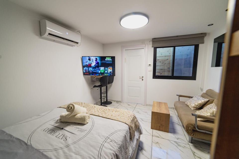 Bed, TV and multimedia, Living room, Seating area, Evening entertainment, Bedroom, air conditioner