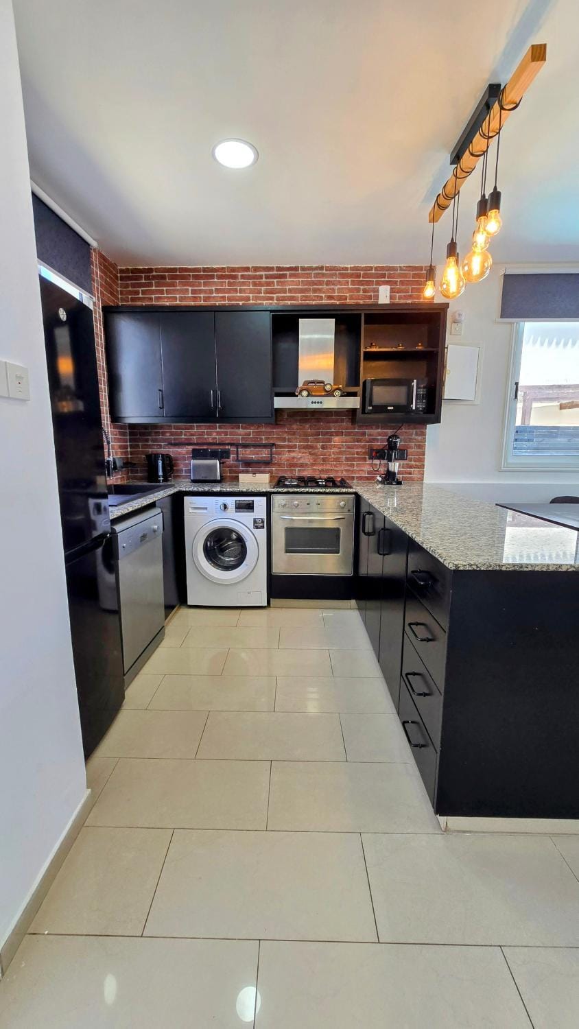 Kitchen or kitchenette, dishwasher, oven, stove, toaster, washing machine