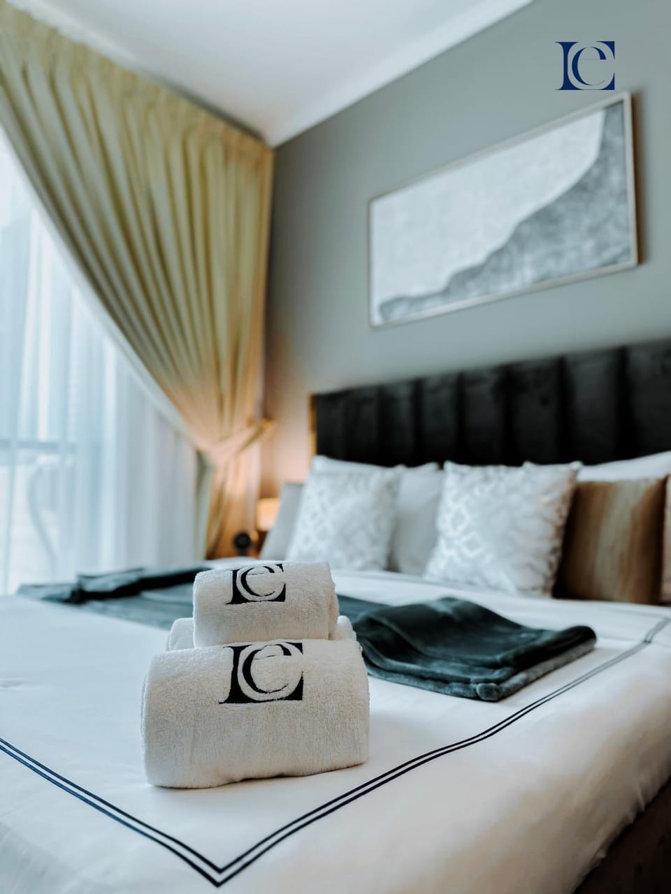 Bed, Photo of the whole room, Text overlay, towels