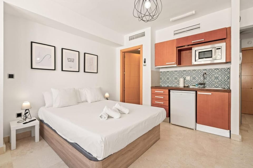 Bed, Kitchen or kitchenette, microwave, stove, towels, air conditioner
