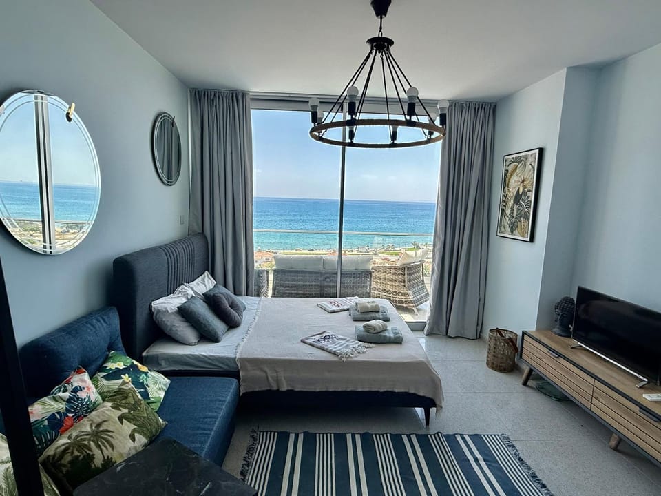 Bed, Natural landscape, TV and multimedia, Living room, Seating area, Bedroom, Sea view