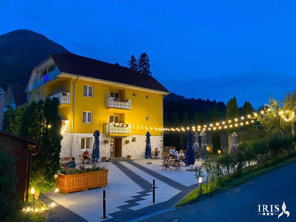 Property building, Restaurant/places to eat, Facade/entrance, Night, People, Balcony/Terrace, Seating area, Dining area, Evening entertainment, Guests, Mountain view, Street view, group of guests, Quiet street view