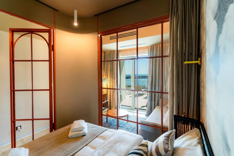 Bed, Natural landscape, View (from property/room), Balcony/Terrace, Living room, Decorative detail, Seating area, Bedroom, Sea view