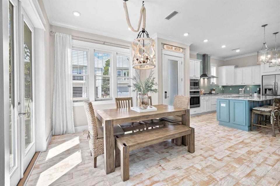 A spacious dining table with wooden chairs and a stylish chandelier for memorable meals.