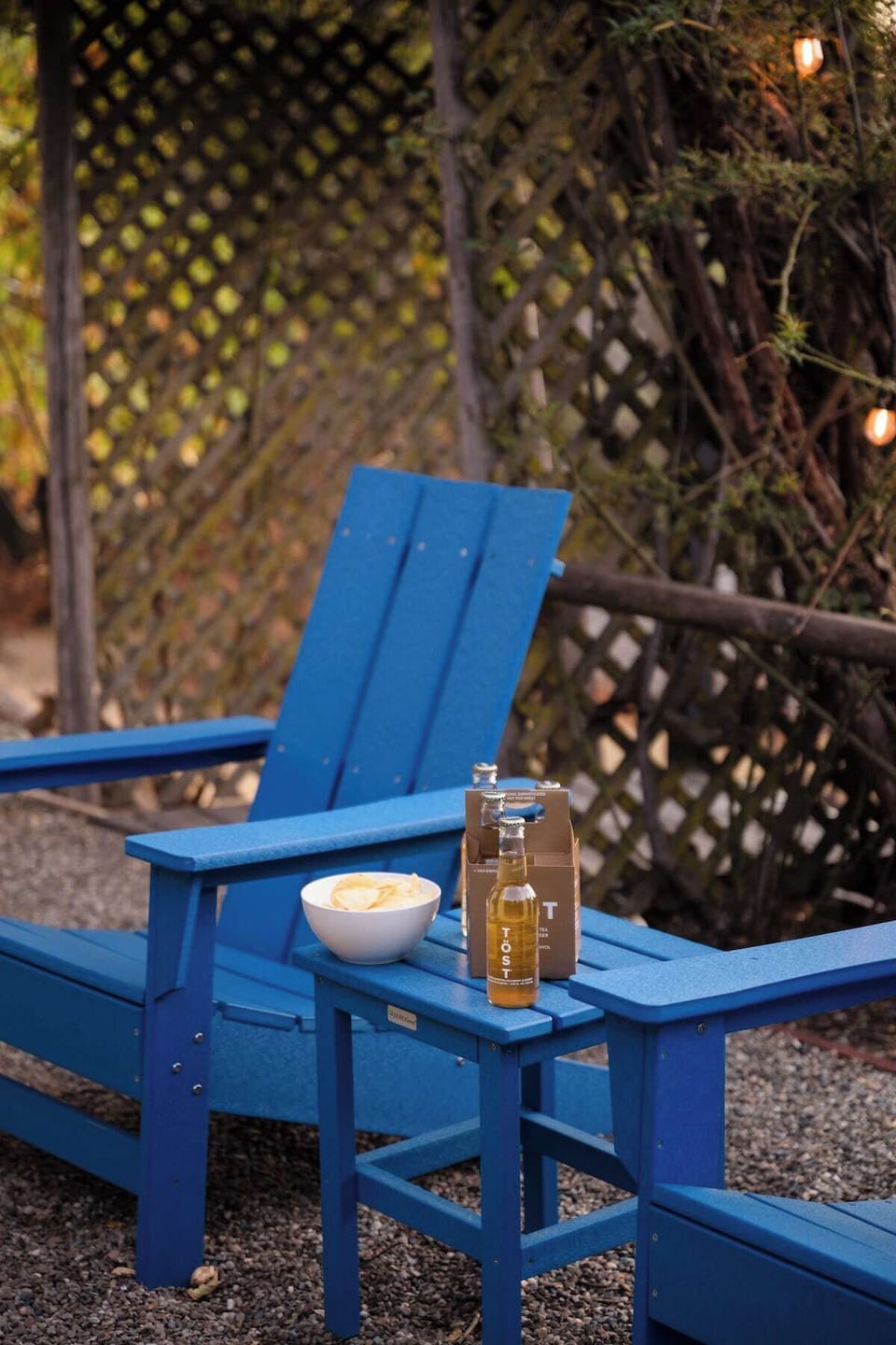 Side patio with 4 adirondack chairs under the programmed string lights. Automatically turn on at sunset and off at 1030PM
