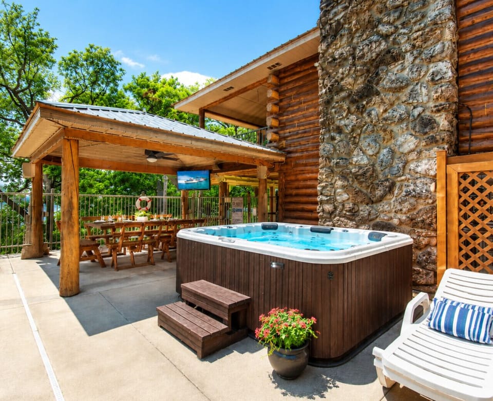 Luxury lakefront log cabin retreat with private hot tub, outdoor dining pavilion, and resort-style amenities in the heart of Lake of the Ozarks.