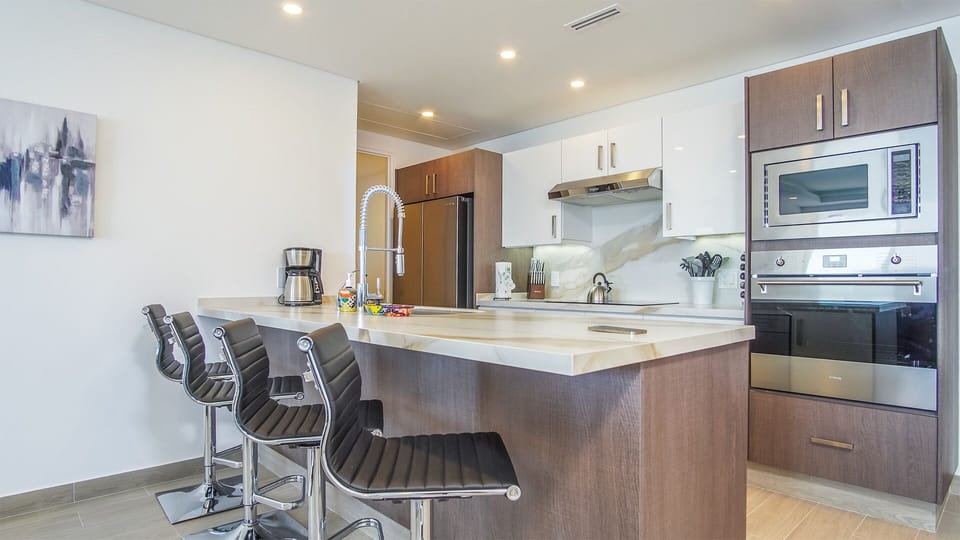 Four upholstered stools at the kitchen counter.