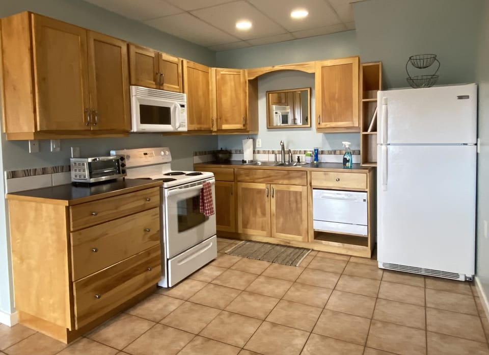 A fully functional kitchen with full size stove, fridge and a small dishwasher