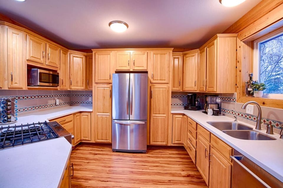 Large open kitchen area with full fridge, coffee, microwave, oven, & dishwasher