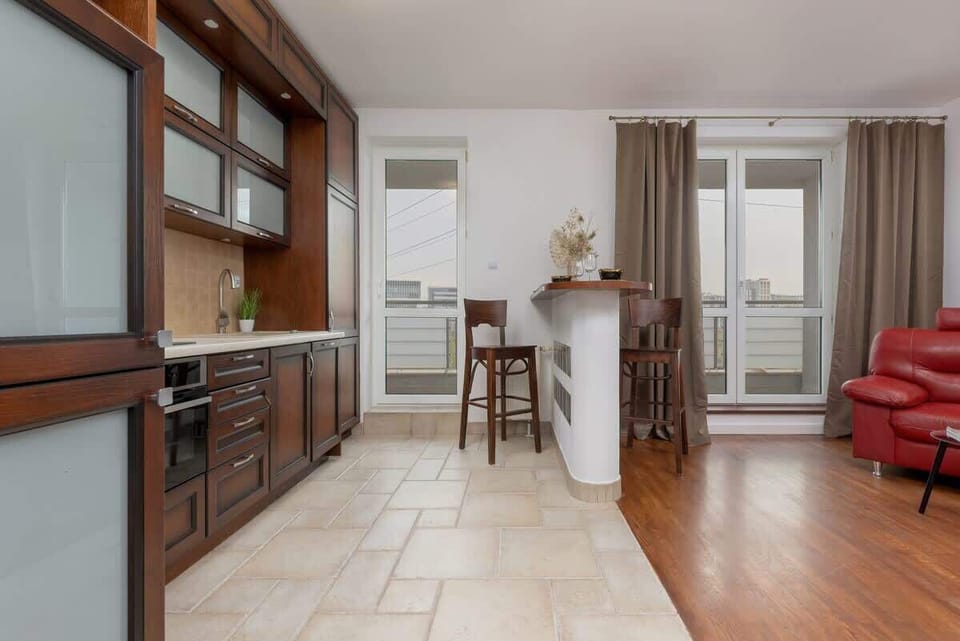 A wide-angle view of the kitchen and dining area, featuring wooden furniture and an open layout.
