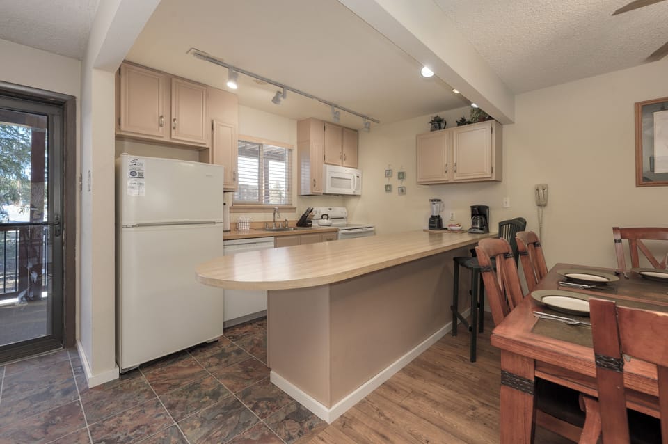 Your fully equipped kitchen features modern appliances and a breakfast bar where you can enjoy morning coffee or casual meals together.