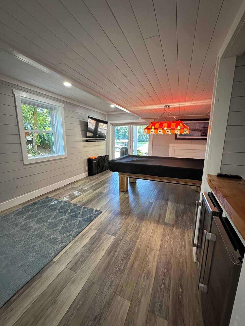 Pool table with small refrigerator, wine refrigerator, large smart TV, cornhole 