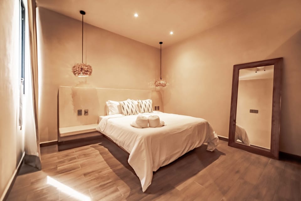 Spacious bedroom with a luxurious large bed in a stylish apartment rental in Tulum