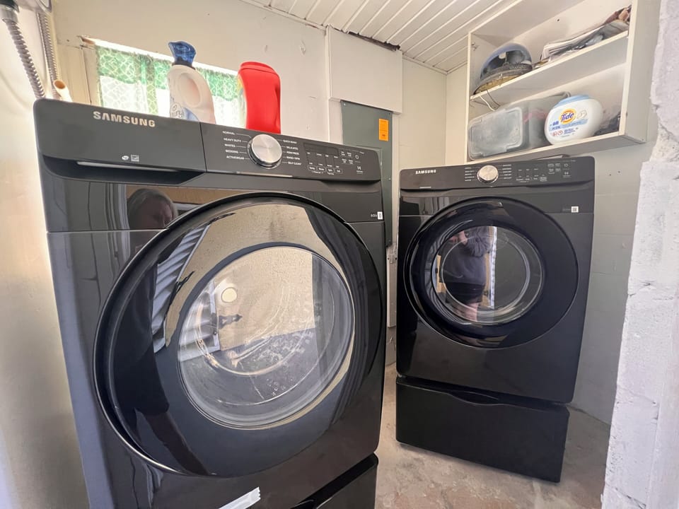 Your private laundry room features modern Samsung washer and dryer with convenient shelving for supplies and detergents.