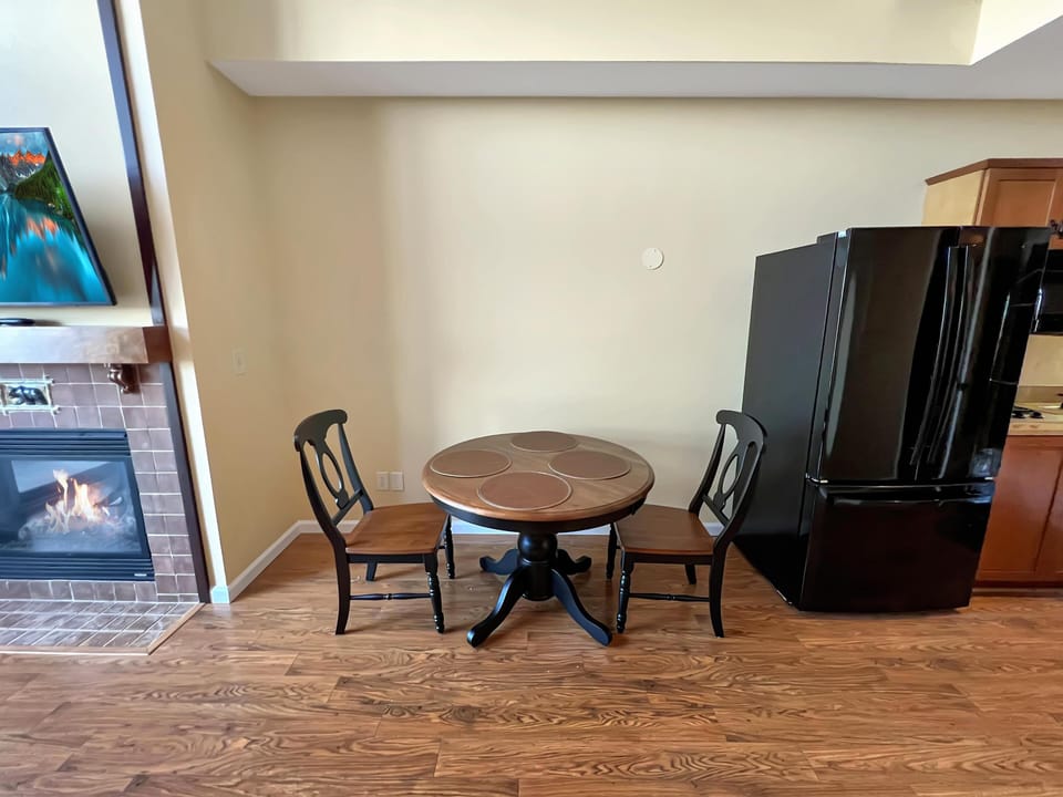 Cozy dining nook with fireplace warmth and modern kitchen nearby