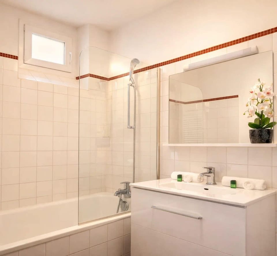 A full equipped bathroom with bath-shower and towels
