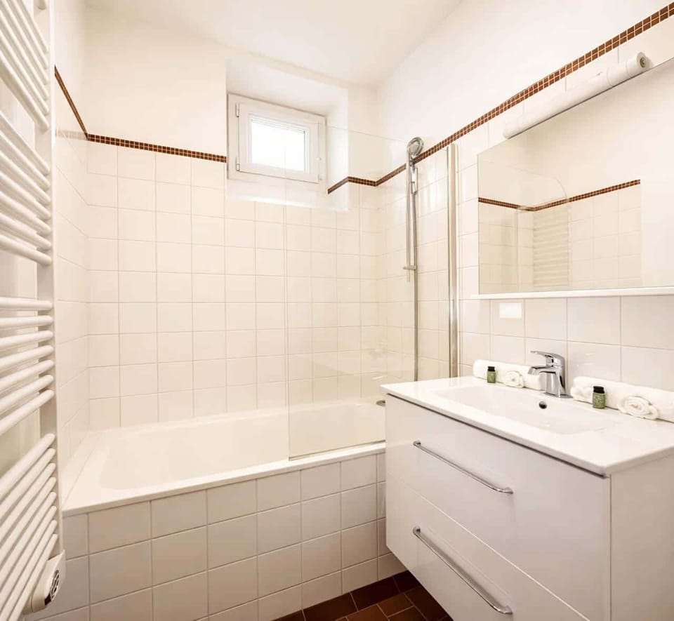 A bathroom well equipped with bath-shower, toilets and brand new sink