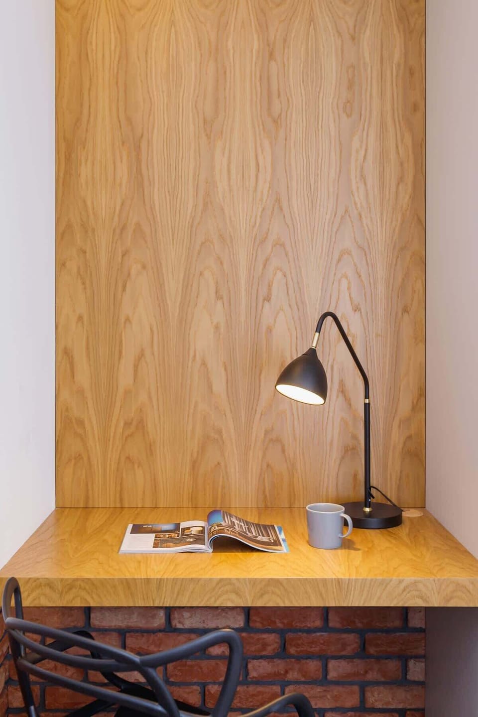  A wooden desk area with a lamp, emphasizing a simple and functional workspace design.
