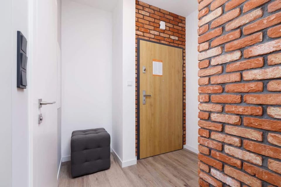 A hallway with exposed brick walls, minimalistic design, and a sleek, contemporary aesthetic.