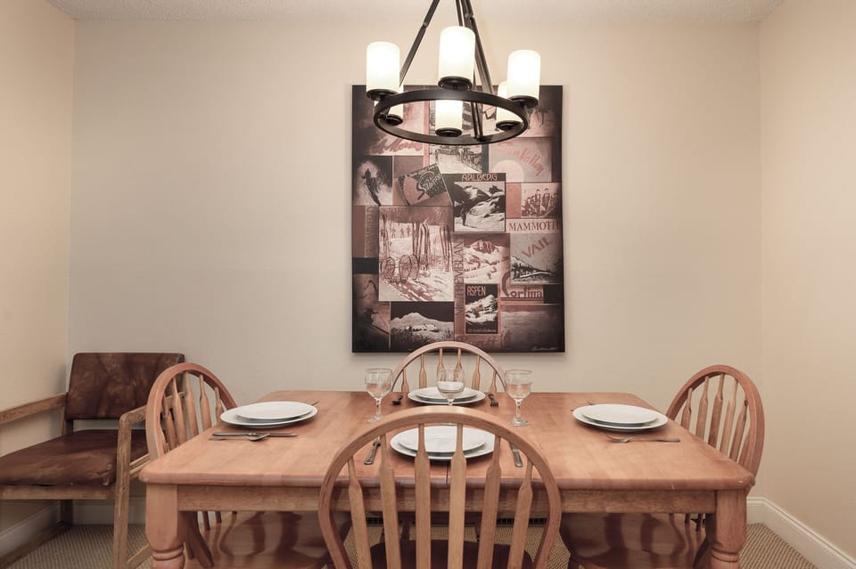 Gather around your welcoming dining table, perfectly set for memorable meals under warm rustic lighting.