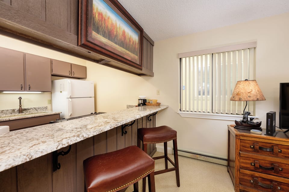 Your fully equipped kitchen features granite countertops, modern appliances, and a convenient breakfast bar for casual dining.