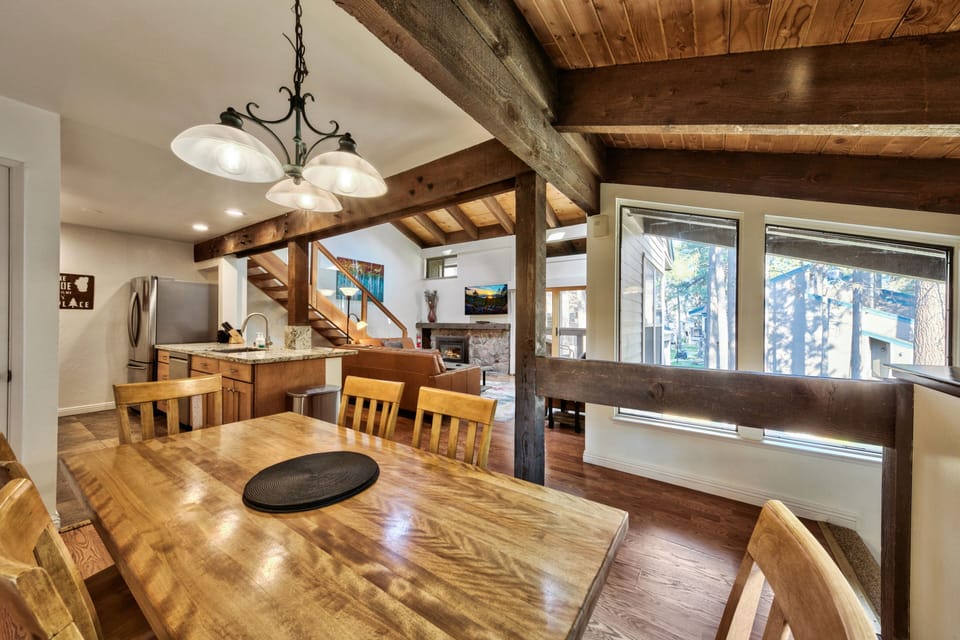 Gather around your rustic dining table under exposed beams, where warm wood tones create the perfect atmosphere for memorable meals together.