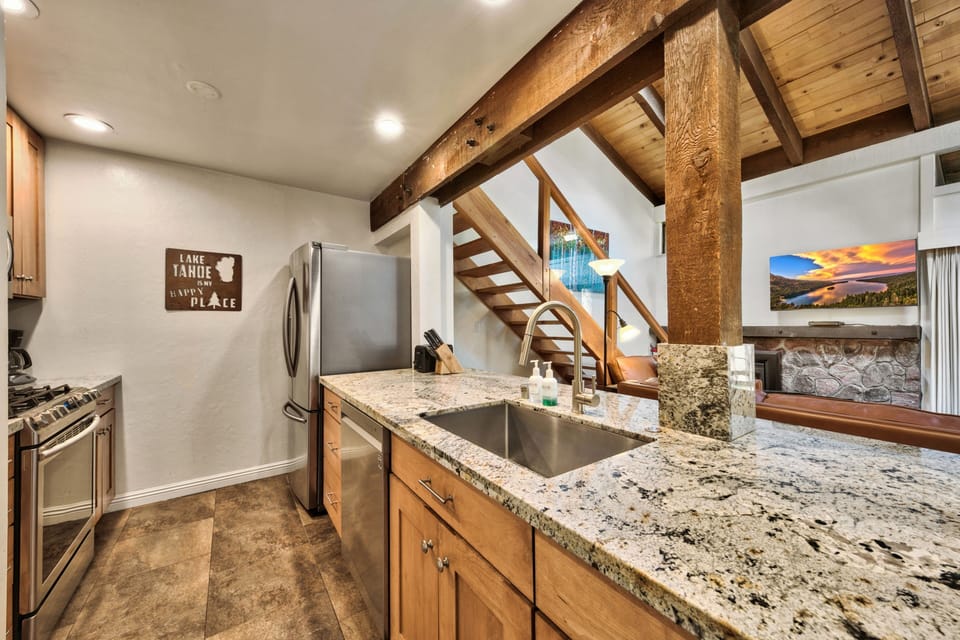 Your kitchen features granite counters, stainless appliances, and rustic exposed beams that create the perfect mountain retreat cooking space.