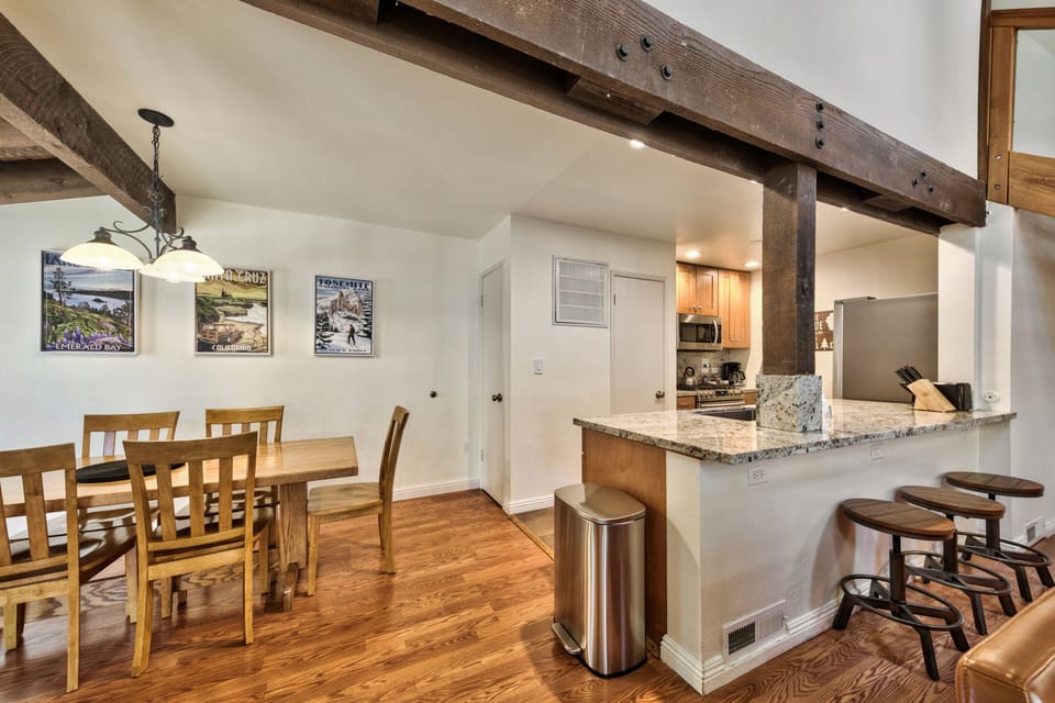 Your open-concept space flows from dining to kitchen, featuring rustic beams and granite counters for memorable meals together.