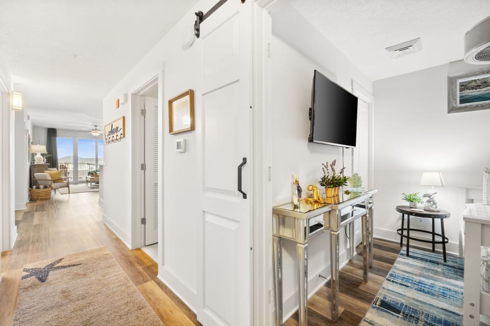 modern hallway with a mounted television and mirrored console table