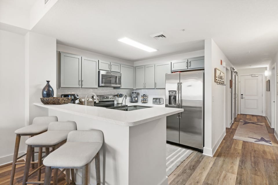 modern kitchen with stainless steel appliances and a breakfast bar with seating