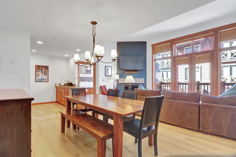 Step into your spacious open-plan retreat where warm wood tones and natural light create the perfect gathering space. You'll love hosting dinner parties at the beautiful dining table while enjoying stunning views through floor-to-ceiling windows.