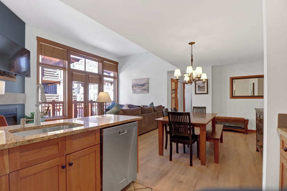 Step into your mountain retreat where warm wood finishes and granite countertops create the perfect gathering space. Cook together in the fully-equipped kitchen, then enjoy meals around the elegant dining table as natural light streams through French doors