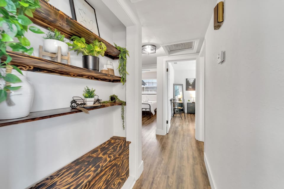 Hallway leading to bedrooms decorated with vibrant greenery.