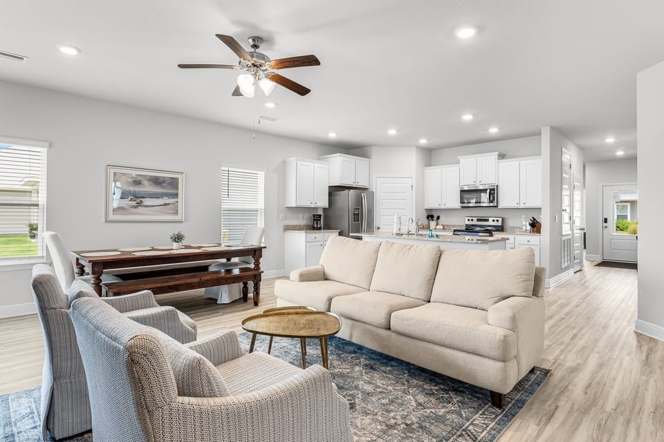 Relax in your open-concept living space with modern furniture, full kitchen, and cozy dining area perfect for memorable meals.