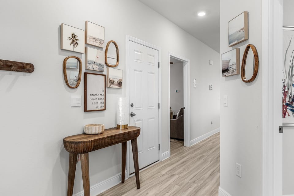 Step into your welcoming entryway where coastal artwork and warm wood accents create an instantly relaxing atmosphere for your coastal getaway.