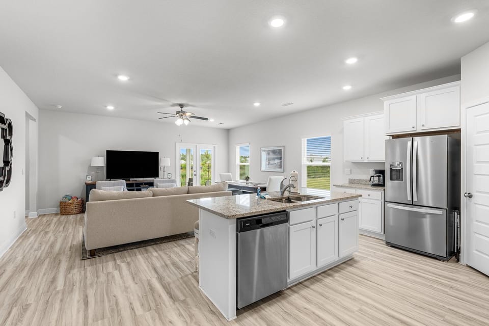 Relax in your spacious open-concept living area with modern kitchen, granite countertops, and stainless appliances flowing seamlessly into the comfortable lounge.