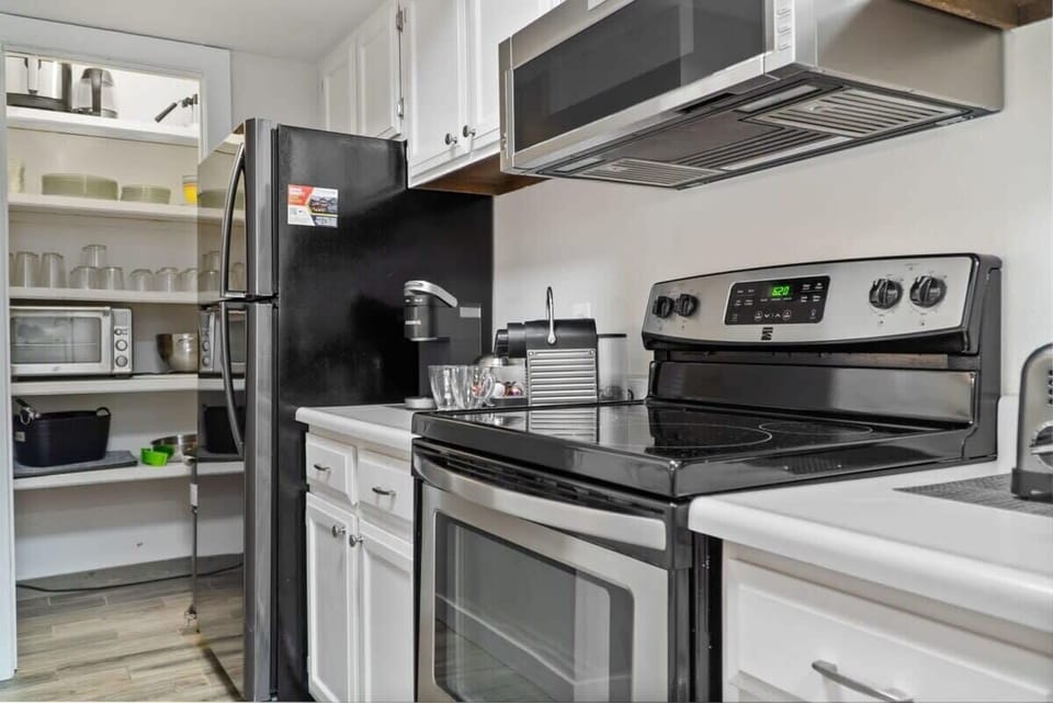 The beautiful kitchen includes a wide range of cookware including, an air fryer, blender, and a crockpot.